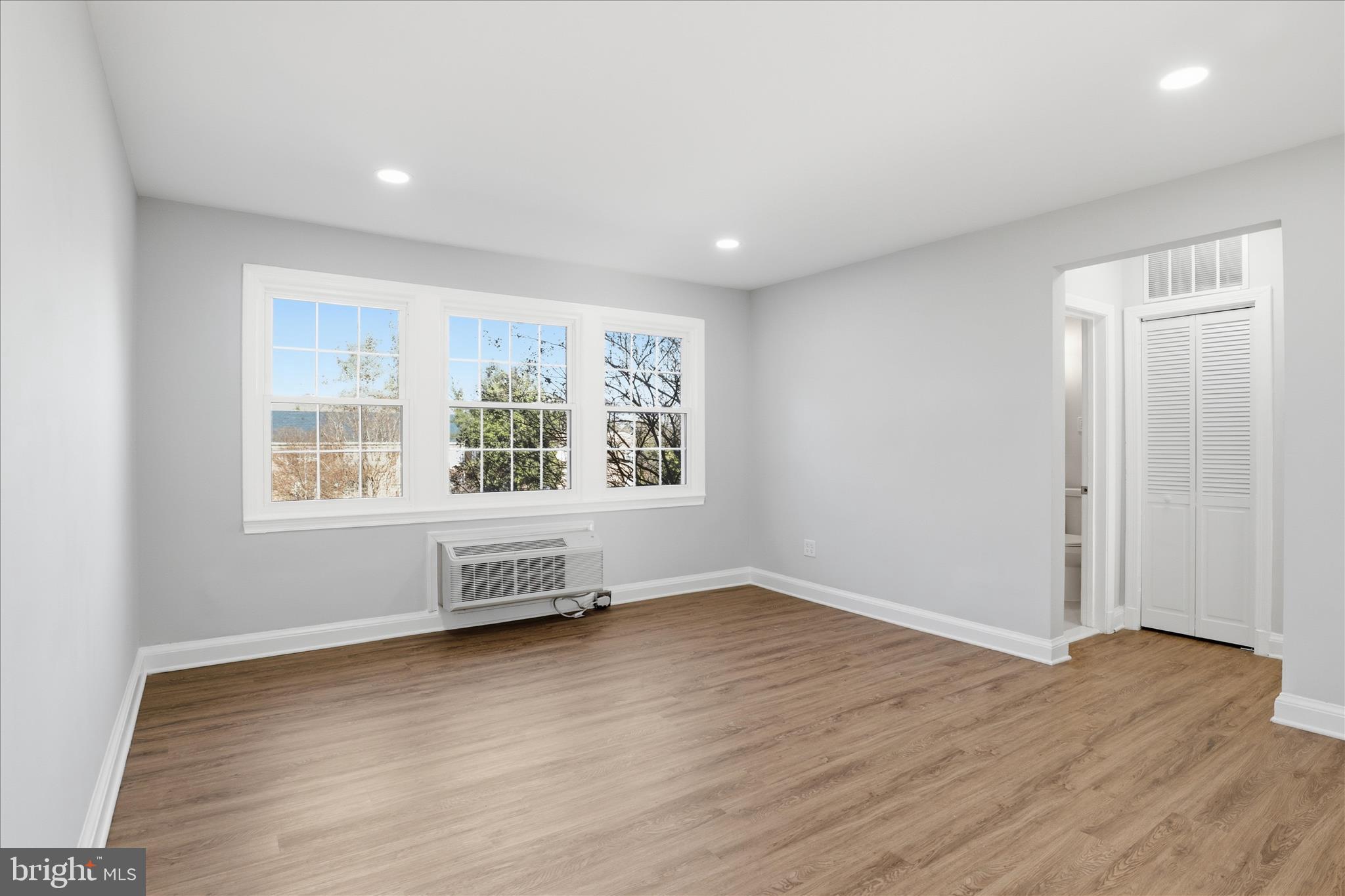 1804 West Abingdon Drive, Unit 201 Alexandria, VA 22314 - Photo 5 of 24 an empty room with wooden floor and windows