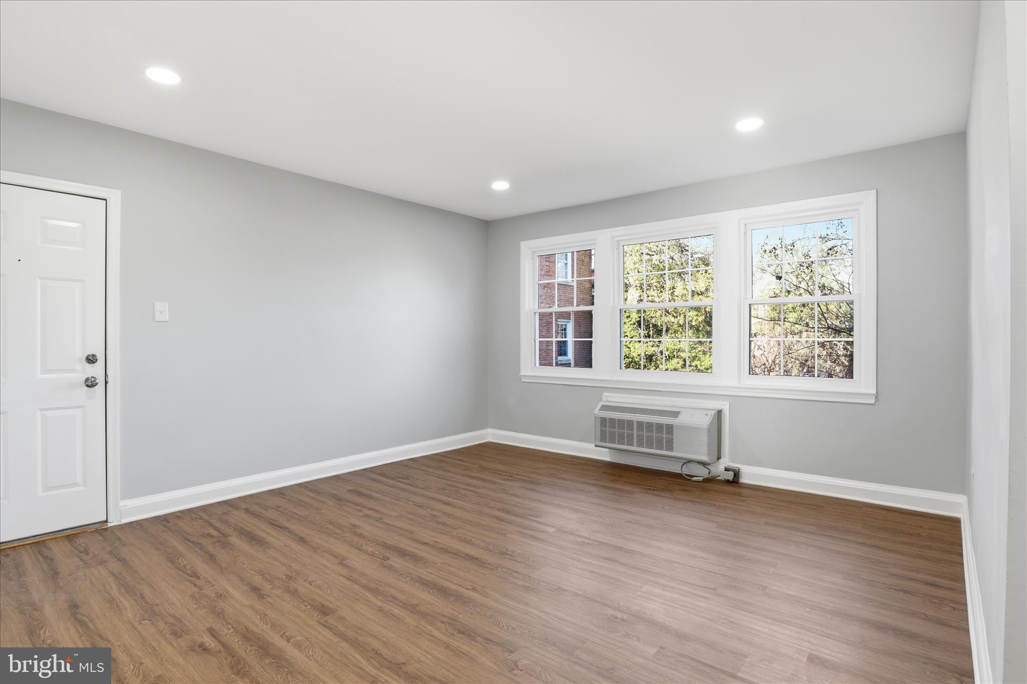 1804 West Abingdon Drive, Unit 201 Alexandria, VA 22314 - Photo 8 of 24 an empty room with wooden floor and windows