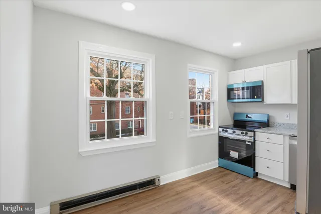 a kitchen with stainless steel appliances a stove top oven a sink a refrigerator and cabinets