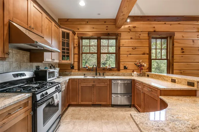 a kitchen with stainless steel appliances granite countertop a sink and a stove