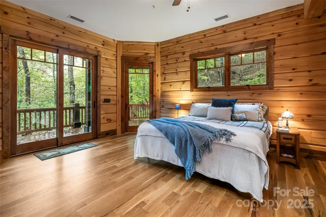 a bedroom with a large bed and wooden floor
