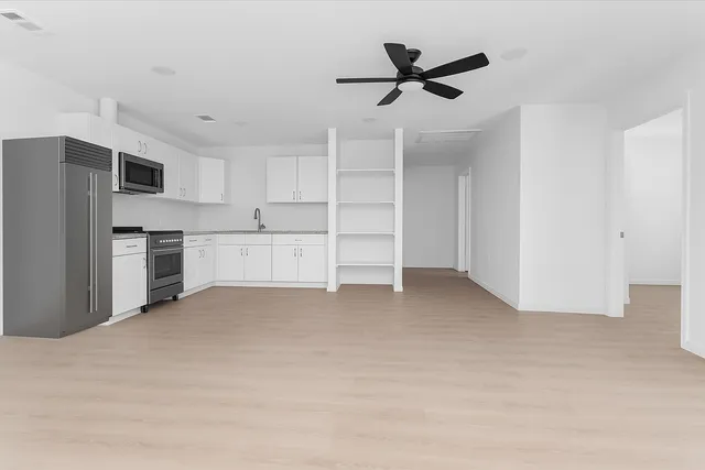 a view of a kitchen with wooden cabinet and stainless steel appliances