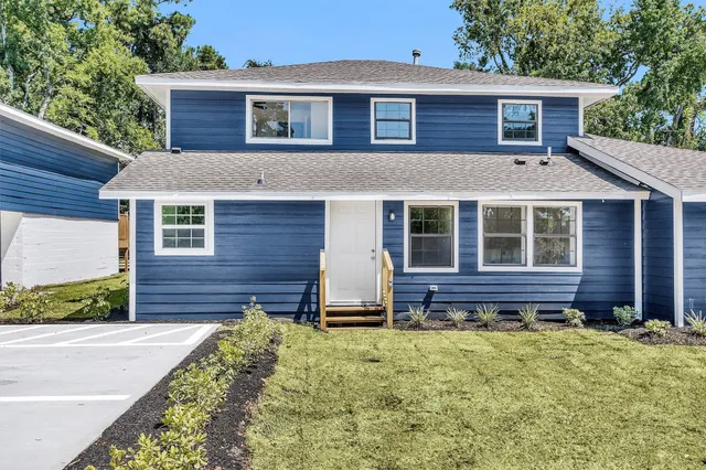 a view of a house with a large window and wooden fence