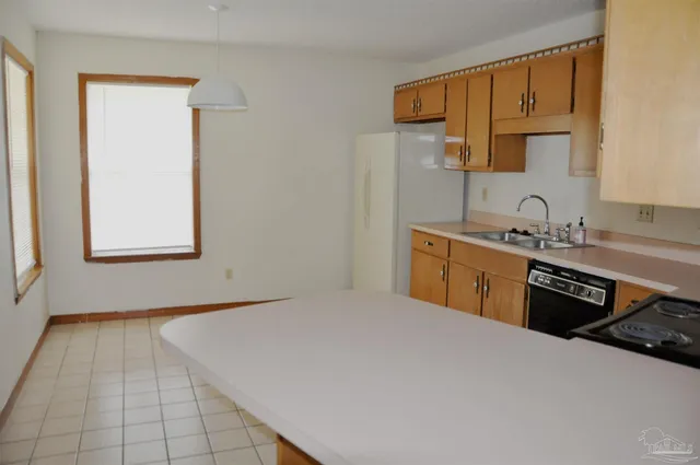 a kitchen with a sink a stove and cabinets