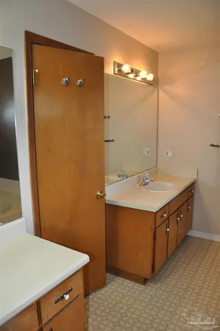 a utility room with a sink a vanity and mirror
