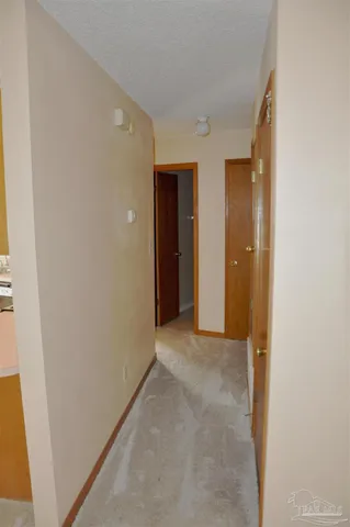 a view of hallway with closet and wooden floor