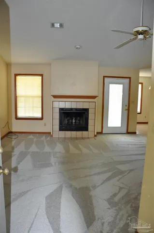 an empty room with windows and fireplace