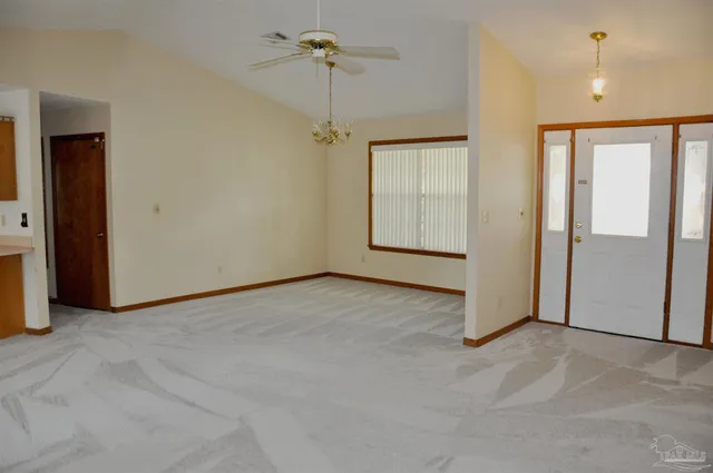 en empty room with closet and a chandelier fan