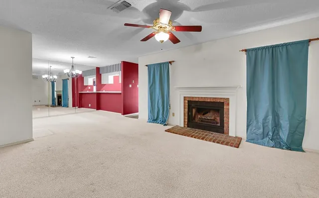 a view of a livingroom with a fireplace fan and a ceiling fan