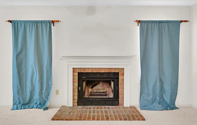 a living room with a fireplace and a rug