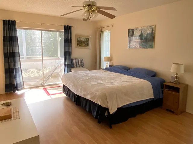 a bed sitting in a spacious bedroom next to a window