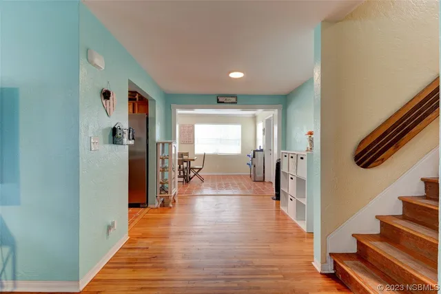 a view of a hallway with wooden floor and staircase