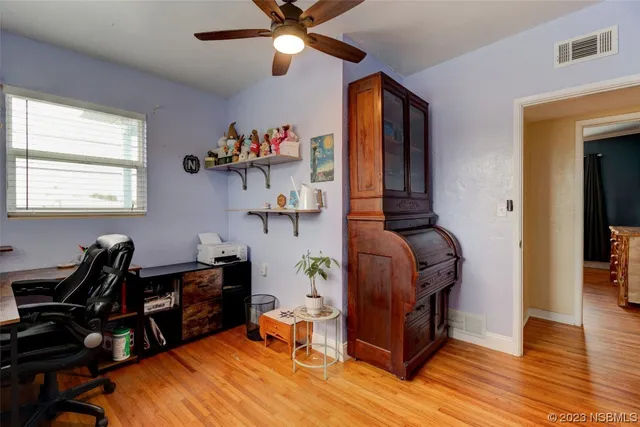 a view of a workspace with furniture and a window