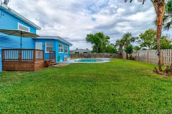 a view of backyard with table and chairs and wooden fence