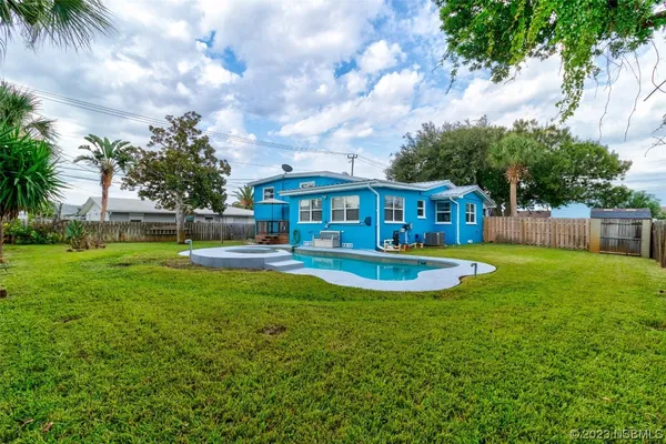 a view of house with swimming pool and sitting area