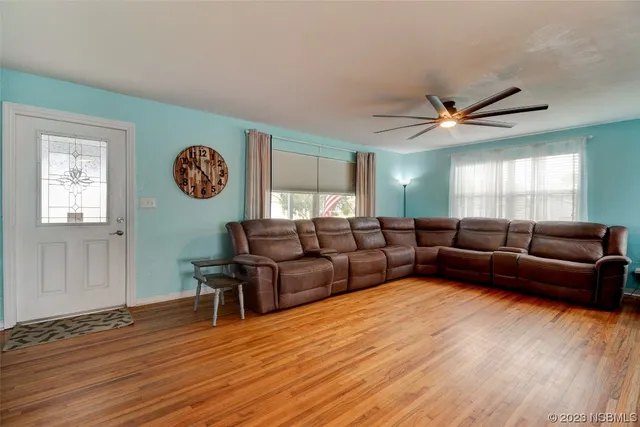 a living room with furniture and a wooden floor