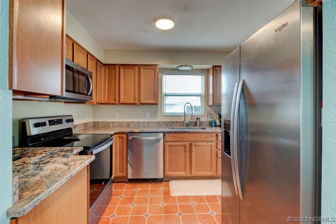 923 Peninsula Drive Ormond Beach, FL 32176 - Photo 8 of 33 a kitchen with stainless steel appliances granite countertop a refrigerator sink and stove