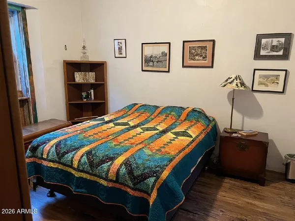 a bedroom with bed and wooden floor