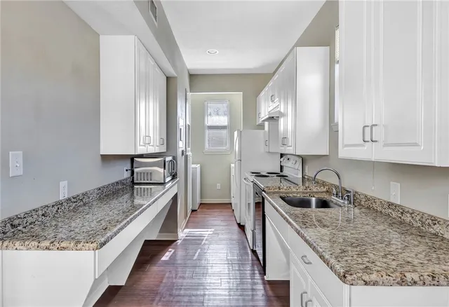 a kitchen with a stove sink and cabinets