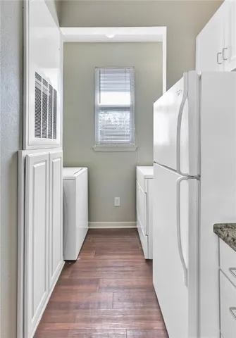 a view of a kitchen with wooden floor and electronic appliances