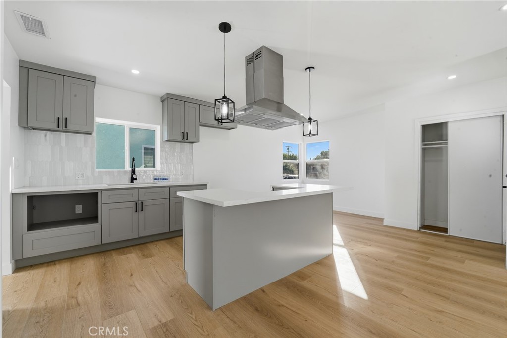 1736 North McDivitt Avenue Compton, CA 90221 - Photo 11 of 30 a kitchen with stainless steel appliances a stove top oven a sink and a wooden floor