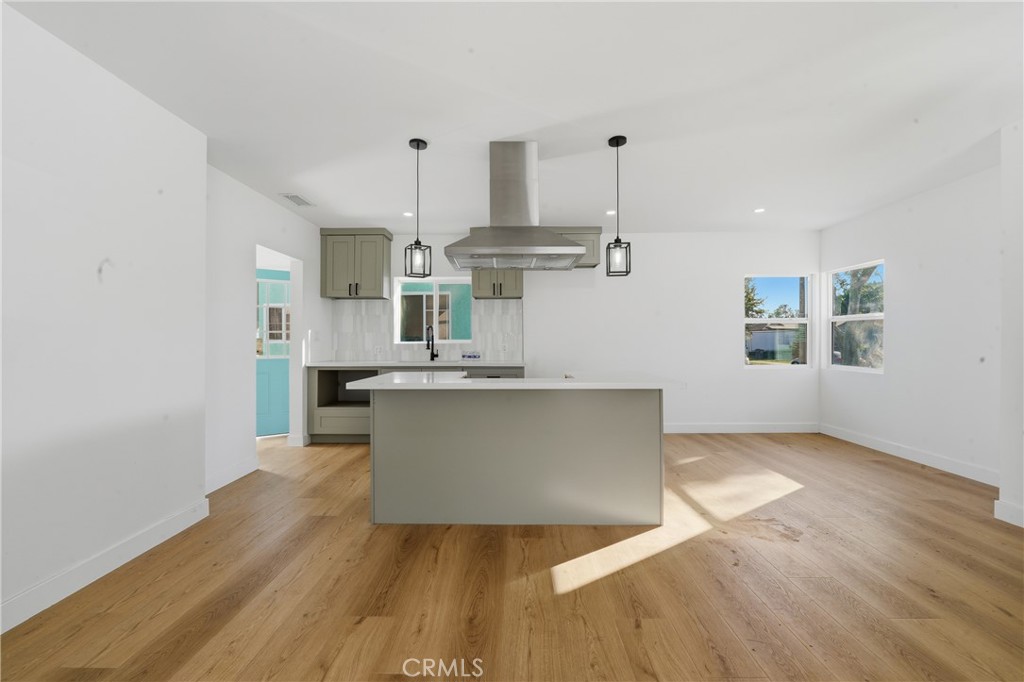 1736 North McDivitt Avenue Compton, CA 90221 - Photo 10 of 30 a living room with kitchen island stainless steel appliances wooden floor and living room view