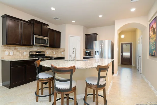a large kitchen with a table and chairs