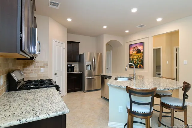 a bed sitting in a bedroom next to a window and a chandelier