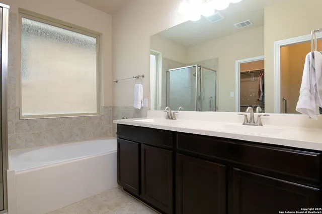 a bathroom with a bathtub a shower and a sink