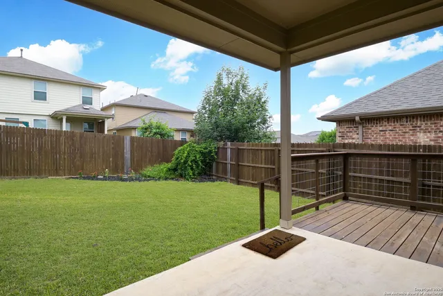 a backyard of a house with barbeque oven and wooden fence
