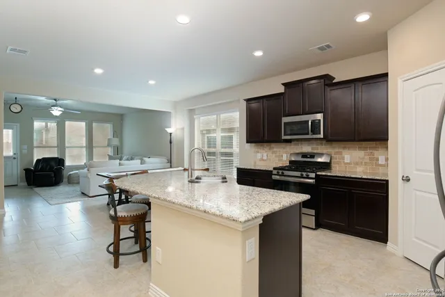 a kitchen with stainless steel appliances wooden cabinets and granite counter tops