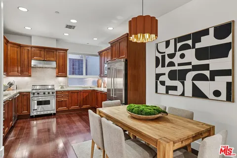 a kitchen with stainless steel appliances granite countertop a sink and a refrigerator