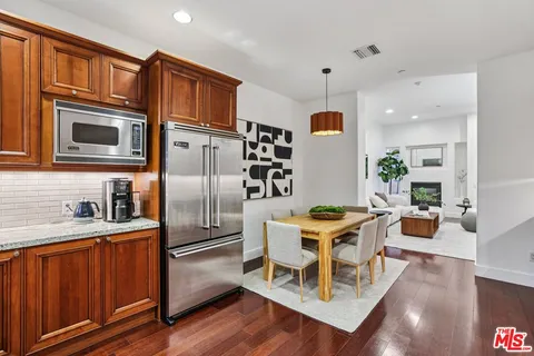 a living room with stainless steel appliances kitchen island granite countertop furniture a refrigerator a sink and a stove