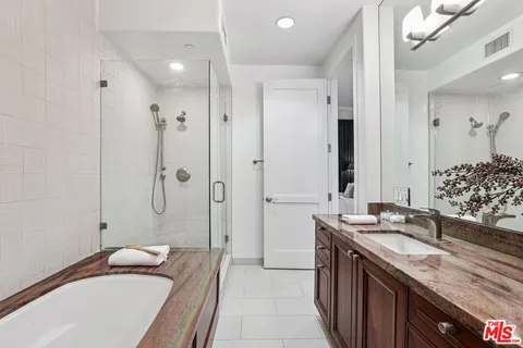 a bathroom with a granite countertop tub sink double vanity granite tub shower and mirror