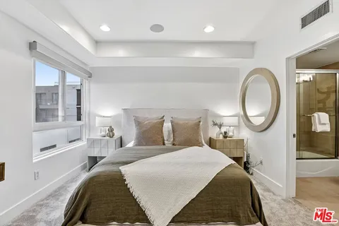 a bed room with a bed a mirror and a window