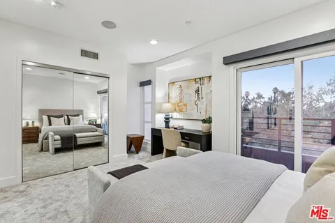 a bedroom with a bed and a large window