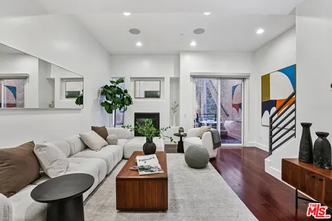 a living room with furniture a fireplace a flat screen tv and potted plant