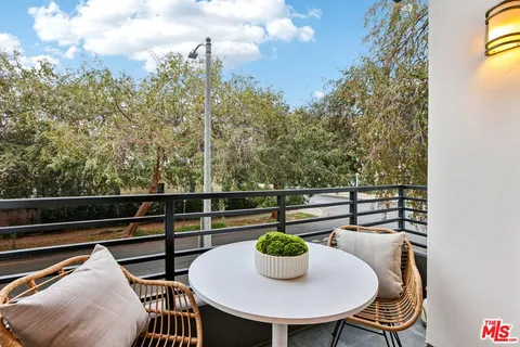 a view of a balcony with table and chairs
