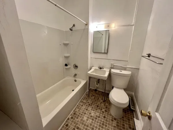 a bathroom with a toilet sink and mirror