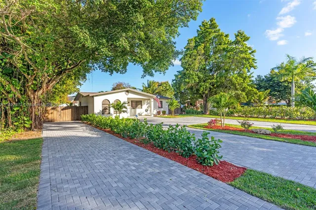 a front view of a house with a yard and a garden