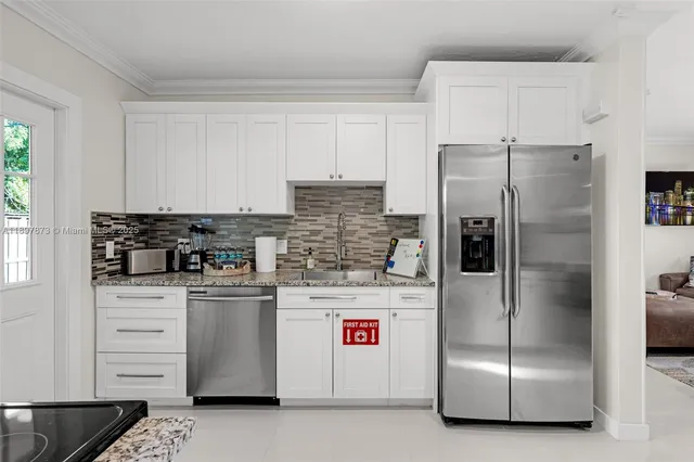 a kitchen with stainless steel appliances a refrigerator sink and cabinets