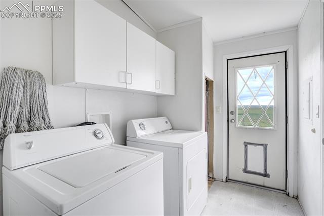 1435 Equestrian Point Yoder, CO 80864 - Photo 18 of 49 Washroom featuring cabinet space, washing machine and dryer, ornamental molding, and light flooring