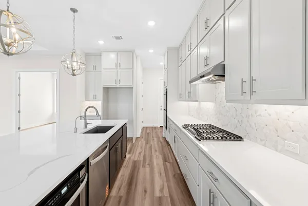 a kitchen with kitchen island granite countertop a sink cabinets a window and stainless steel appliances