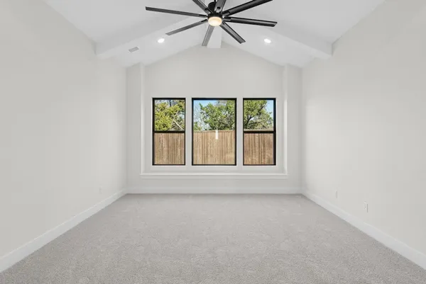 an empty room with a window and a fan