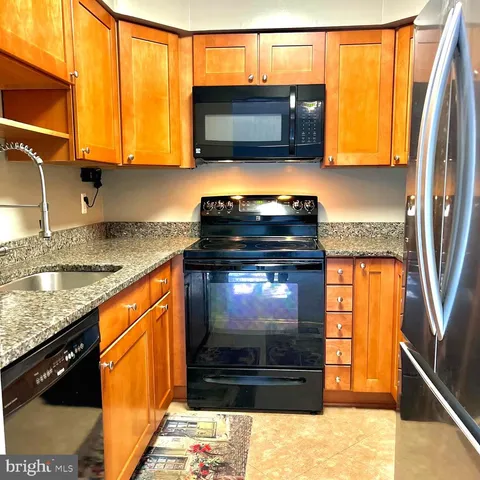 a kitchen with stainless steel appliances granite countertop a stove a microwave and a sink