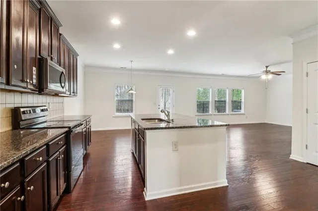 a kitchen with stainless steel appliances granite countertop a stove a sink and a refrigerator