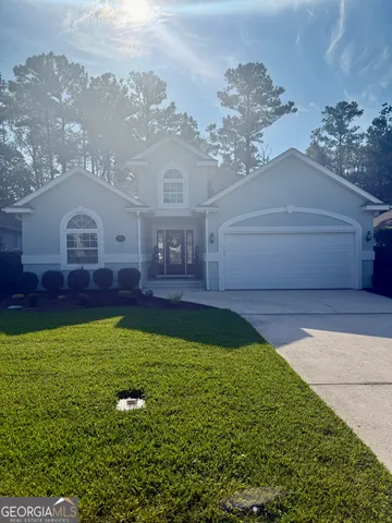 a view of a house with a big yard potted plants and large tree