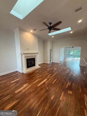 a view of empty room with wooden floor and fireplace