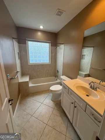 a bathroom with a double vanity sink toilet mirror and window