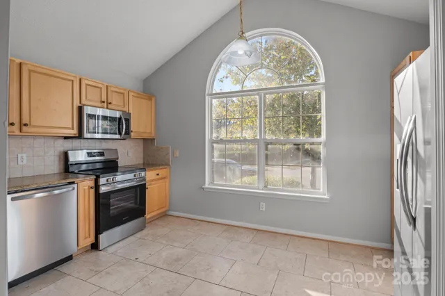 a kitchen with stainless steel appliances granite countertop a stove top oven a sink and a microwave